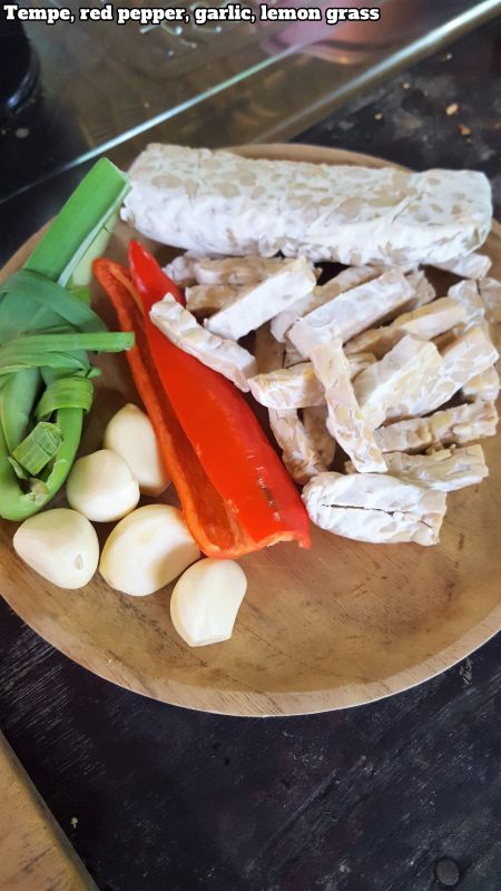 Bali Farm Cooking School. Tempe, garlic, red pepper, lemon grass on a wooden plate.