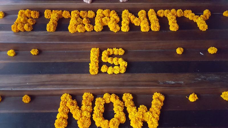 Clear Café. Stufen mit Blumen. Auf den Stufen zum Spa- und Toilettenbereich ist zu lesen "Eternity is now" aus lauter orangen, aneinandergereihten Blüten.
