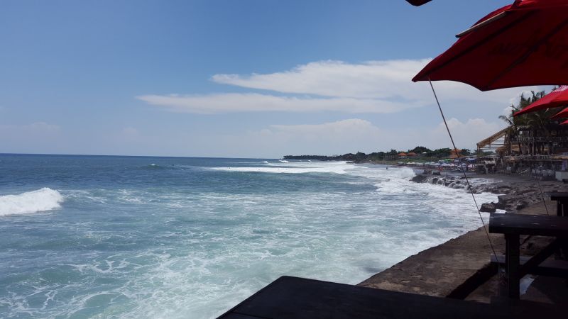 Dian Cafe Canggu. View. Eyes heading westwards. Ocean, waves, surfers, the nearby beach.