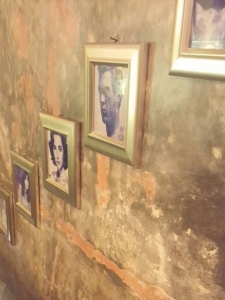 Lazy Cats. Wall with Pictures. Staircase with portrait photos in frames. The wall is stained as if it was very old.