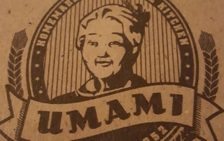 Umami Logo. Umamischriftzug in geschwungener Banderole, dahinter da Abbild einer älteren asiatischen Dame. Umami logo. Umami lettering in a curved banderole, behind it a picture of an elderly Asian lady.