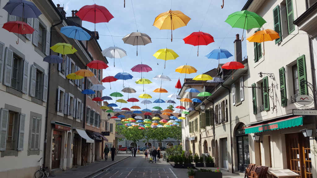 Carouge art installation with colorful umbrellas above the street.